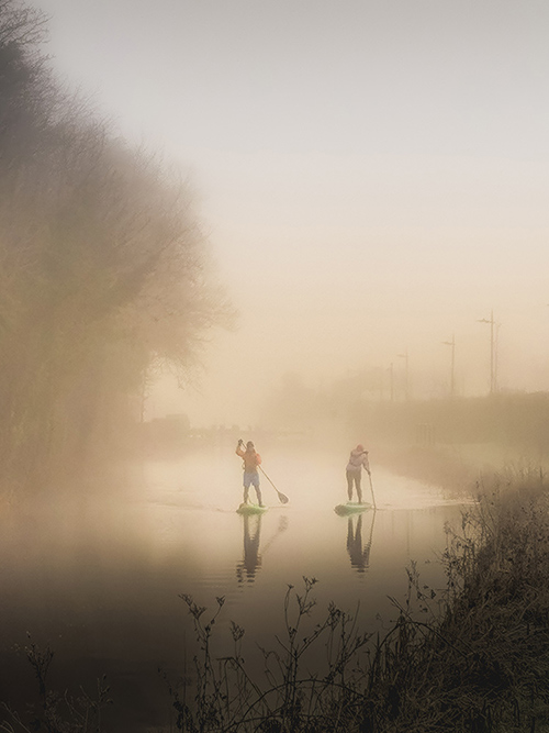 Two paddle boarders on the Royal Canal on a foggy day in Dublin